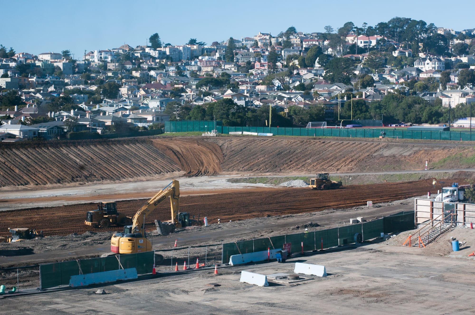 The beginning phase of construction for the Balboa Reservoir housing project (top) sits below the start of construction for the Diego Rivera Theater Performing Arts and Education Center (in front of the green fence) on Ocean Campus.