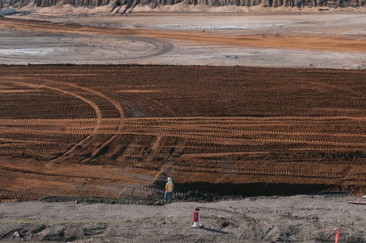 A construction worker stands looking over the area of the new site for the Balboa Reservoir housing project on Ocean Campus