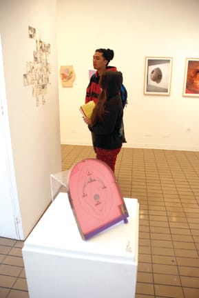 Pap Art_DSC_1548_online City College students Marissa Juvera and Armand Beltran adminre artwork at the "Pap Art" exhibit at the City Arts Gallery in the Visual Arts Building. JOSEPH PHILLIPS / THE GUARDSMAN