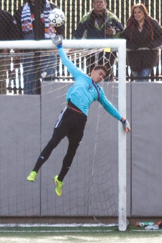 Rams goalkeeper Emmanuel Jimenez palms the ball away.