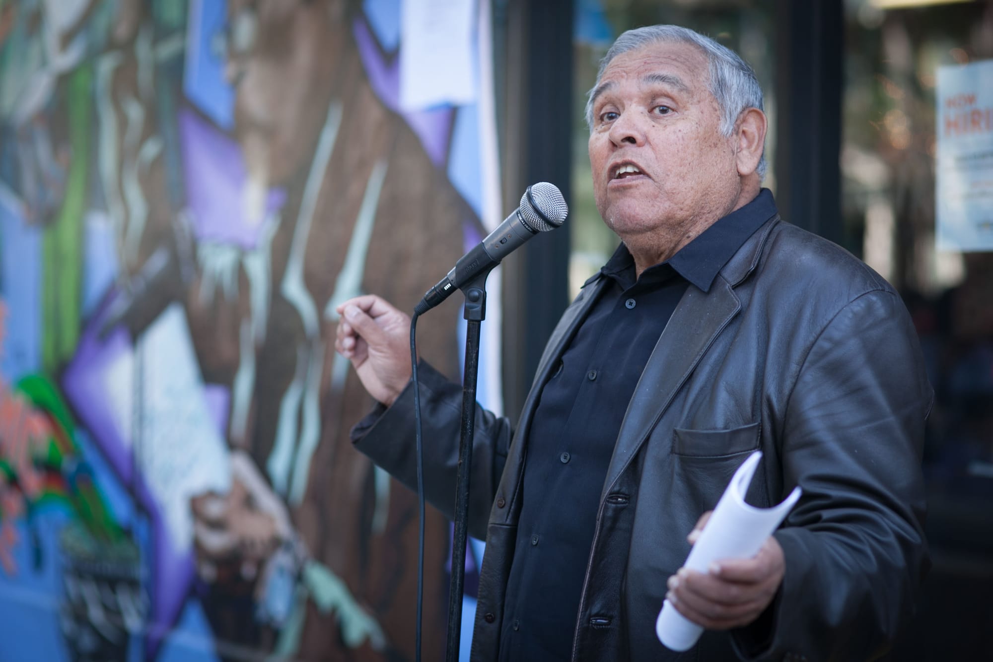 The founder of El Tecolote newspaper Juan Gonzales speaks to the crowd during the celebration of the mural project, which completed by Precita Eyes Muralists Association and Center at the corner of 24th and Folsom streets, San Francisco on Saturday, Aug. 8, 2015. (Photo by Ekevara Kitpowsong/TheGuardsman)
