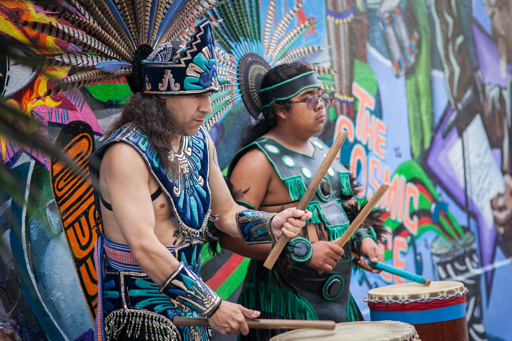 (L-R) Drumming performance by Bismarck Delgado and Chicome Malinallo (Frank Cortes) during traditional Mexican spiritual dance celebrating the opening of the mural titled “This Place” on the corner of 24th and Folsom streets. Saturday, Aug. 8, 2015. (Photo by Ekevara Kitpowsong/TheGuardsman)