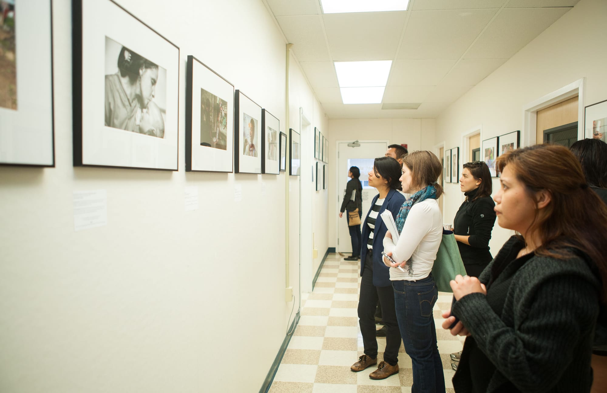 Guests view photographs of “Faces of Hope” exhibition at Front Page Gallery during the opening reception on Thursday, Sept. 17, 2015. (Photo by Ekevara Kitpowsong/The Guardsman)