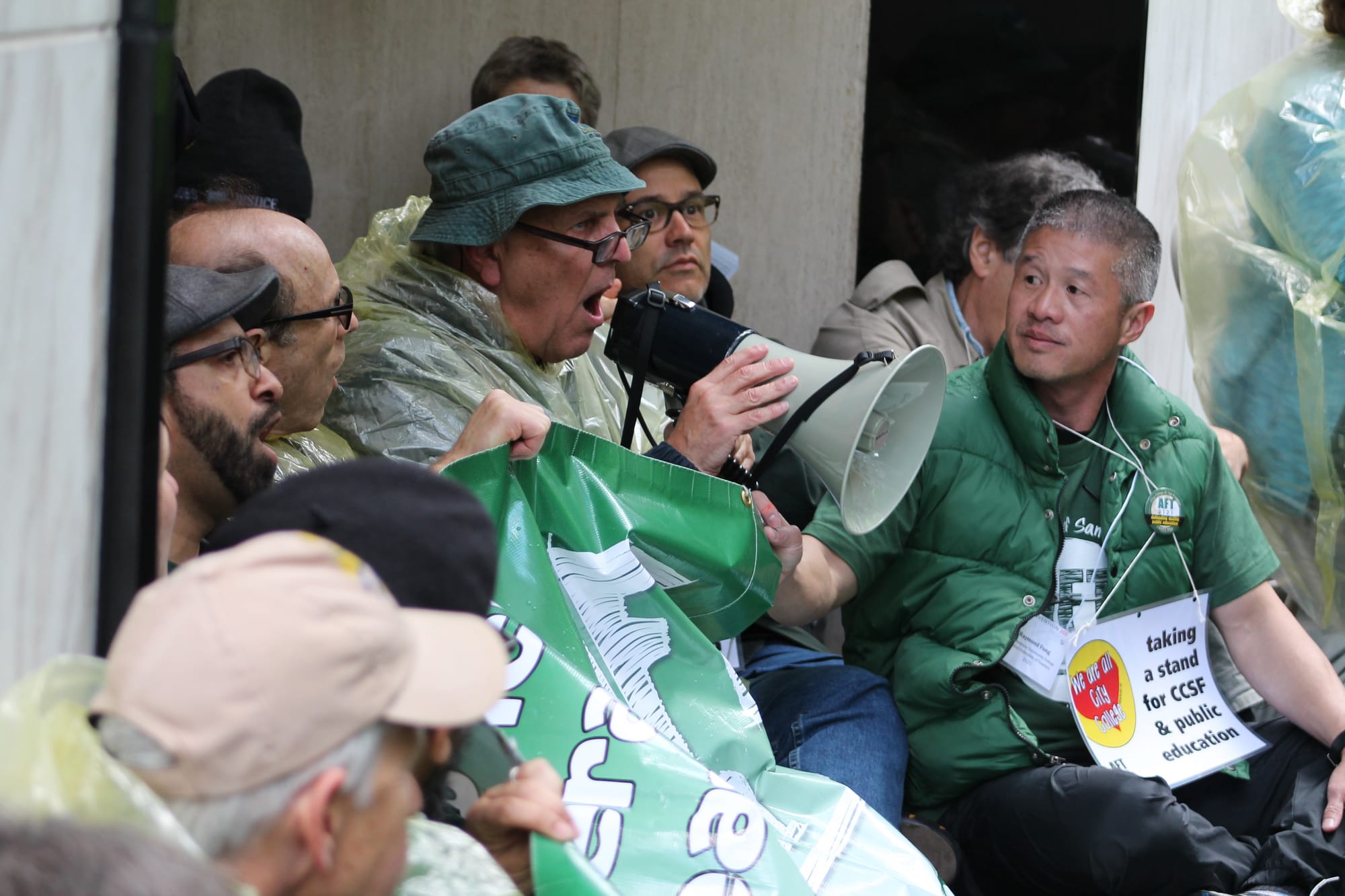 A protestor calls for higher quality public education through his megaphone as faculty block Jeff Sloan's office doorway, the district's lead negotiator on Narch 11, 2016. (Audrey Garces/The Guardsman)