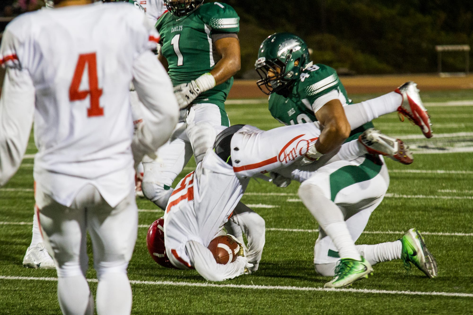 Rams wide receiver Chikwado Nzerem, center, is tackled by a Laney College player after making a catch in the game on Sept. 2. (Photo by Gabriela Reni/The Guardsman)