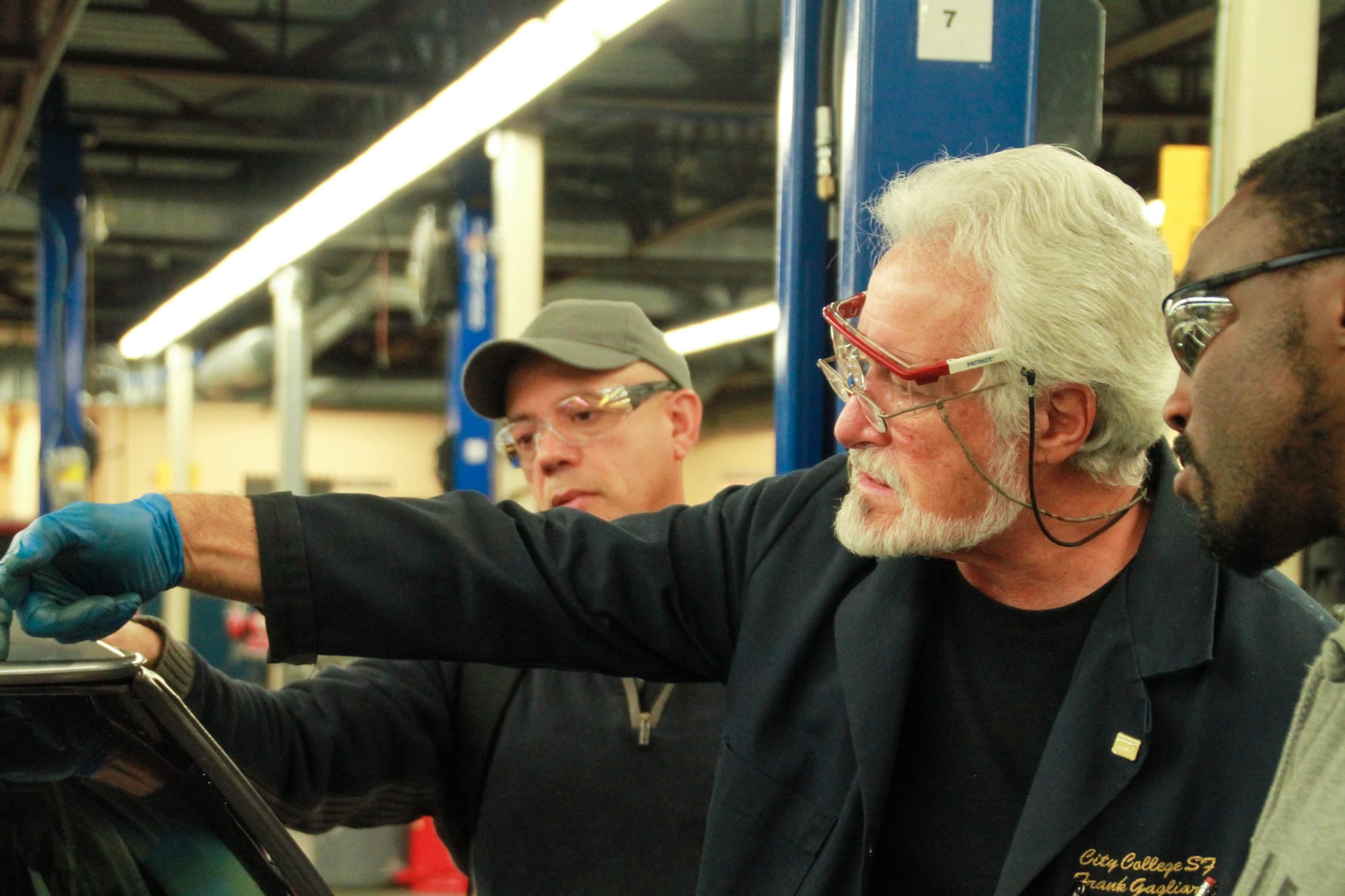 Instructor Frank Gagliardi teaches students by helping them fix problems with their cars at the Evans Campus on April. 12, 2017