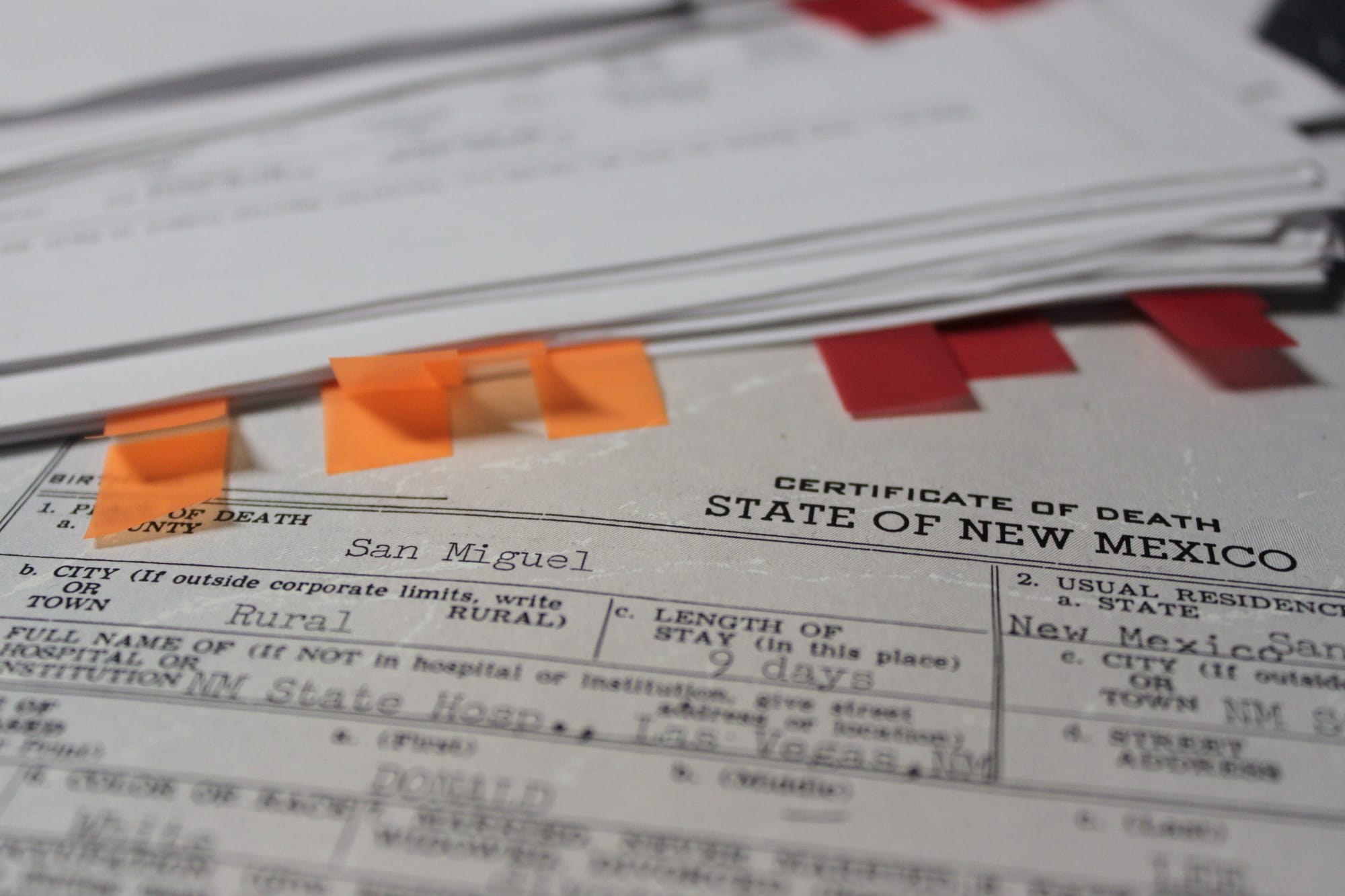 Donald Ray Lee’s death certificate lies underneath stacks of research granddaughter and reporter, Bethaney Lee, compiled during her investigation. Photo contributed by Jacob Lee. Taken on Oct. 21, 2017.