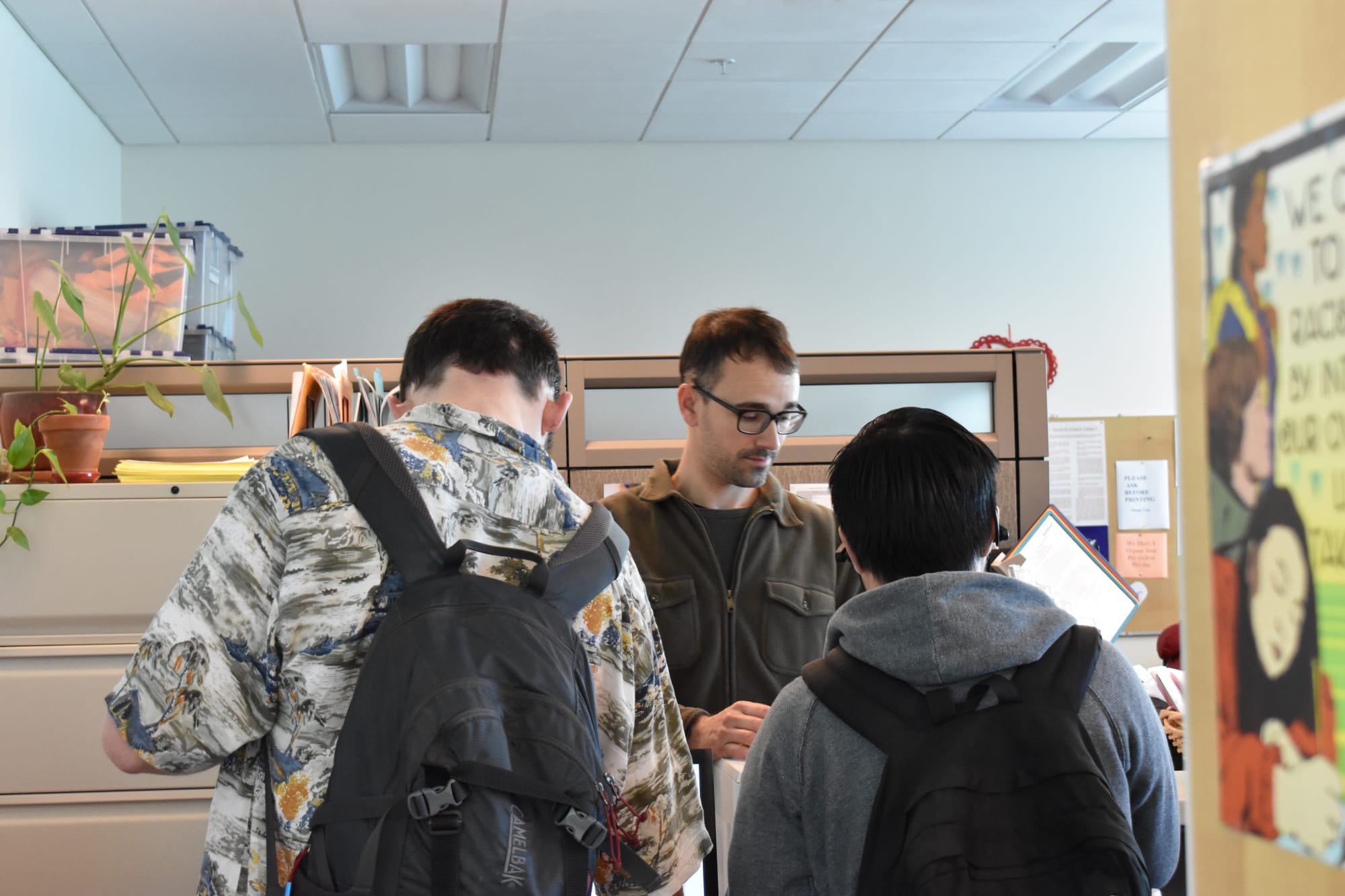 Health Education Program Manager, Andrew Ciscel, is helping with printing and resources for student, Taylor Laviolette, who is wearing a hawaiian shirt in the link center on Feb. 15, 2017. Photo by Veronica Steiner/The Guardsman.