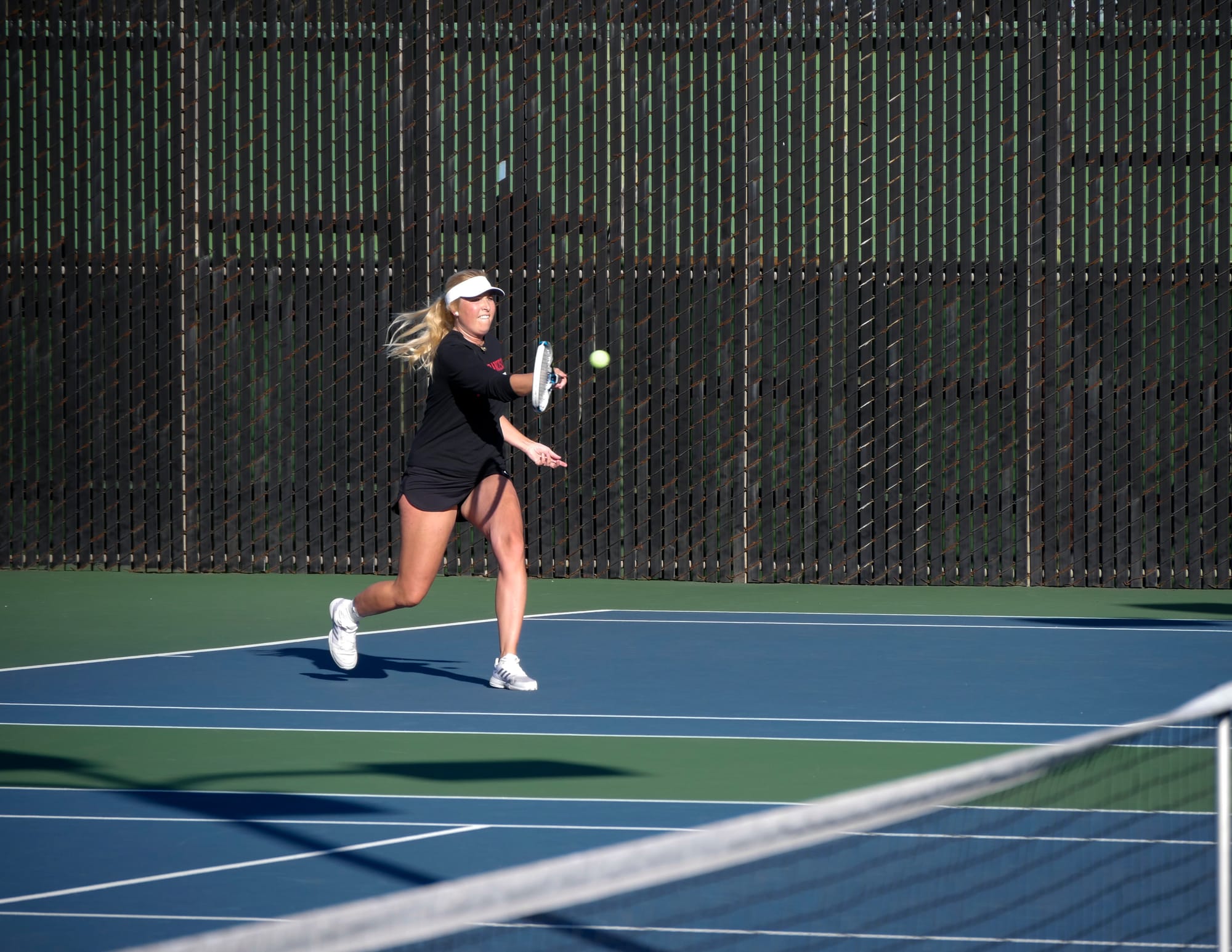 The Rams freshman Caroline Olander fore-hands a strike against Mission College on March 2, 2018. Photo by James Comfort/Special to The Guardsman.