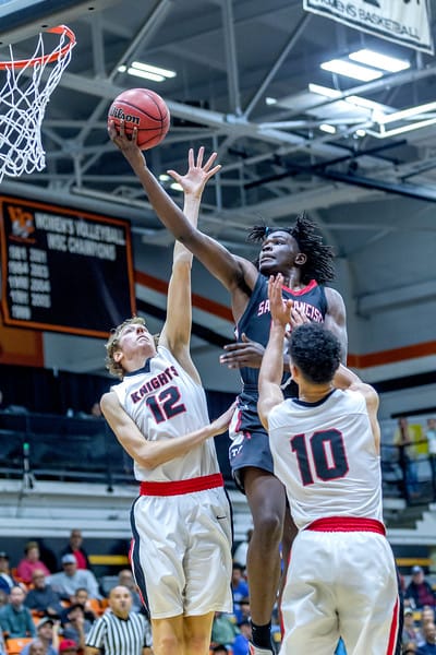Sophomore guard Michael Wright (#55) drives in-between two San Diego City College players for the finger roll layup during the CCCAA State Title game in Ventura on March 13, 2018. Photo by Peter Wong/Special to The Guardsman.